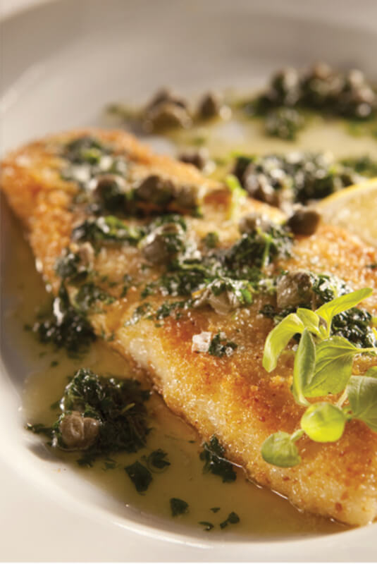 a fish fillet garnished and in oil
