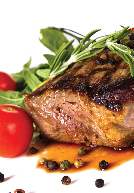 image of a steak with pepporcorn sauce garnished with tomatos and salad leaves